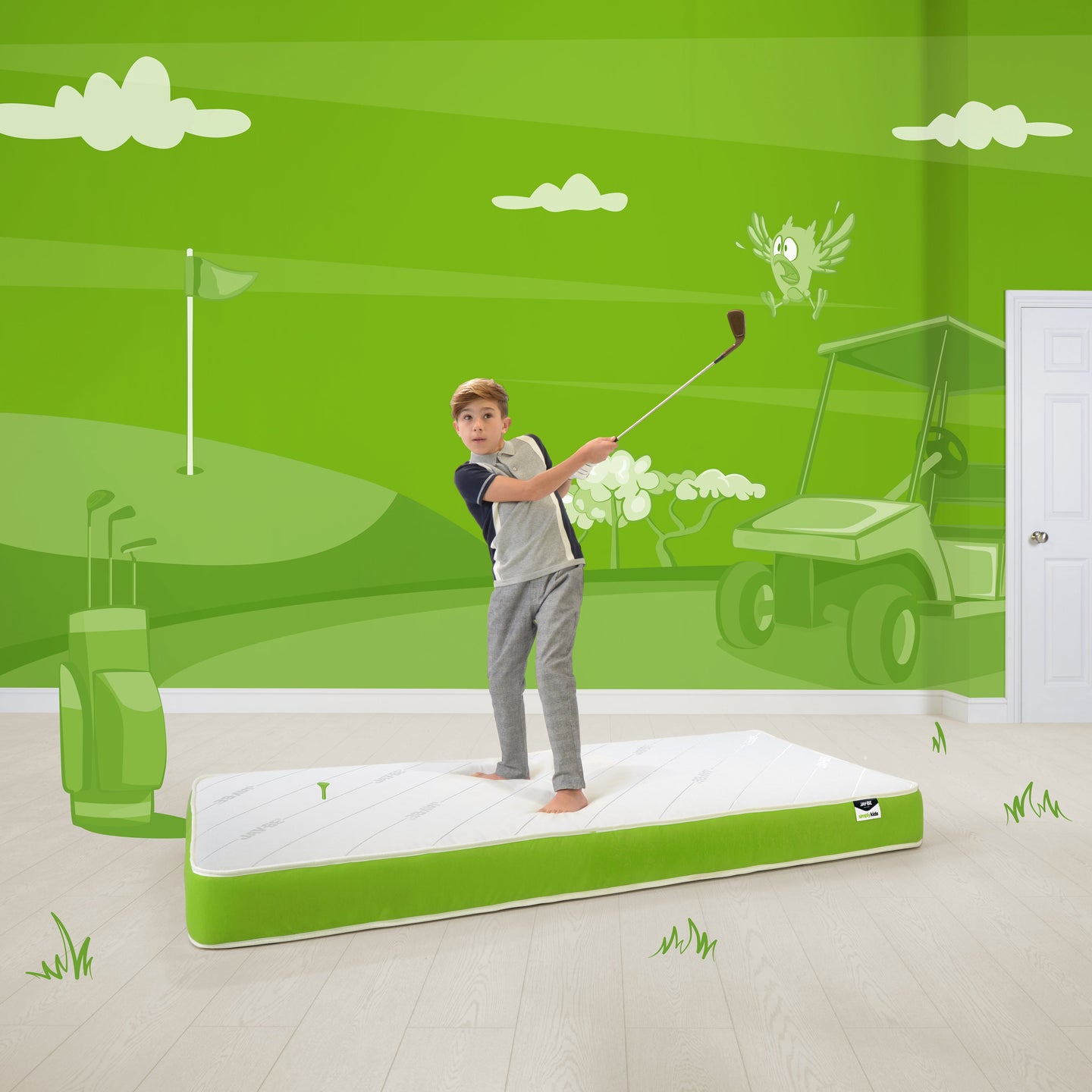 Eco-friendly Jay-Be Anti-Allergy Foam Free Sprung Single Mattress with Purotex® technology for allergen reduction and moisture absorption, shown in a vibrant green-themed room with a child playing golf on the mattress.