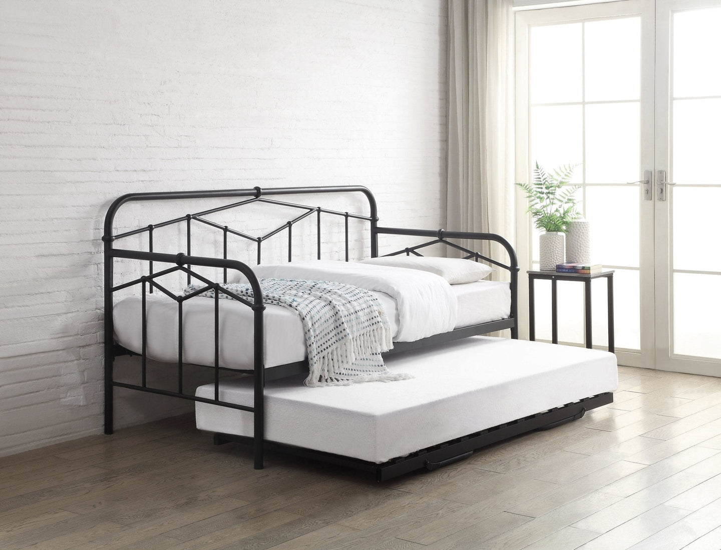 Axton Day Bed in black, featuring Art Deco design with geometric panels and pull-out guest bed in a modern interior setting.