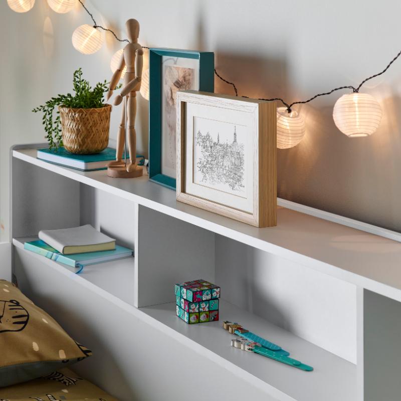 The Oliver Bunk Bed with storage shelves and decorative items.