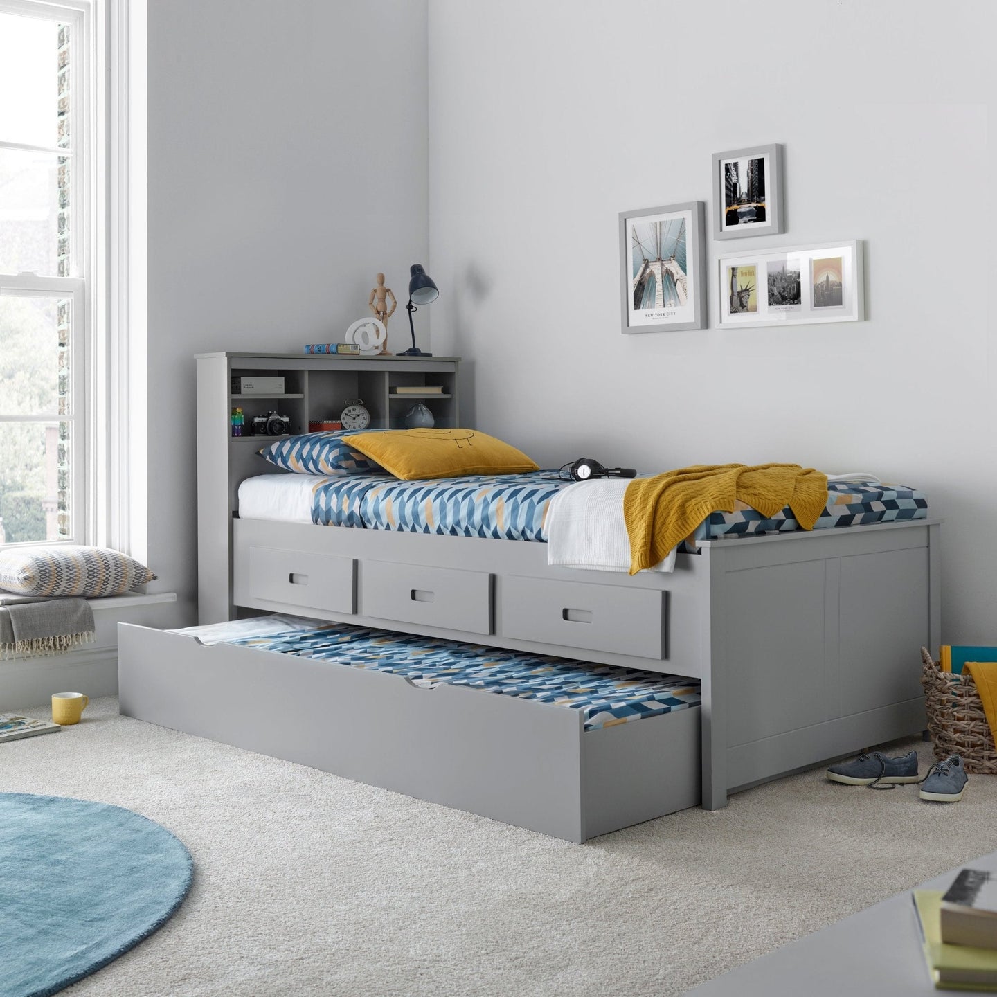 Veera Guest Bed with Optional Trundle in a modern bedroom setting, featuring pull-out drawers and a shelf headboard.