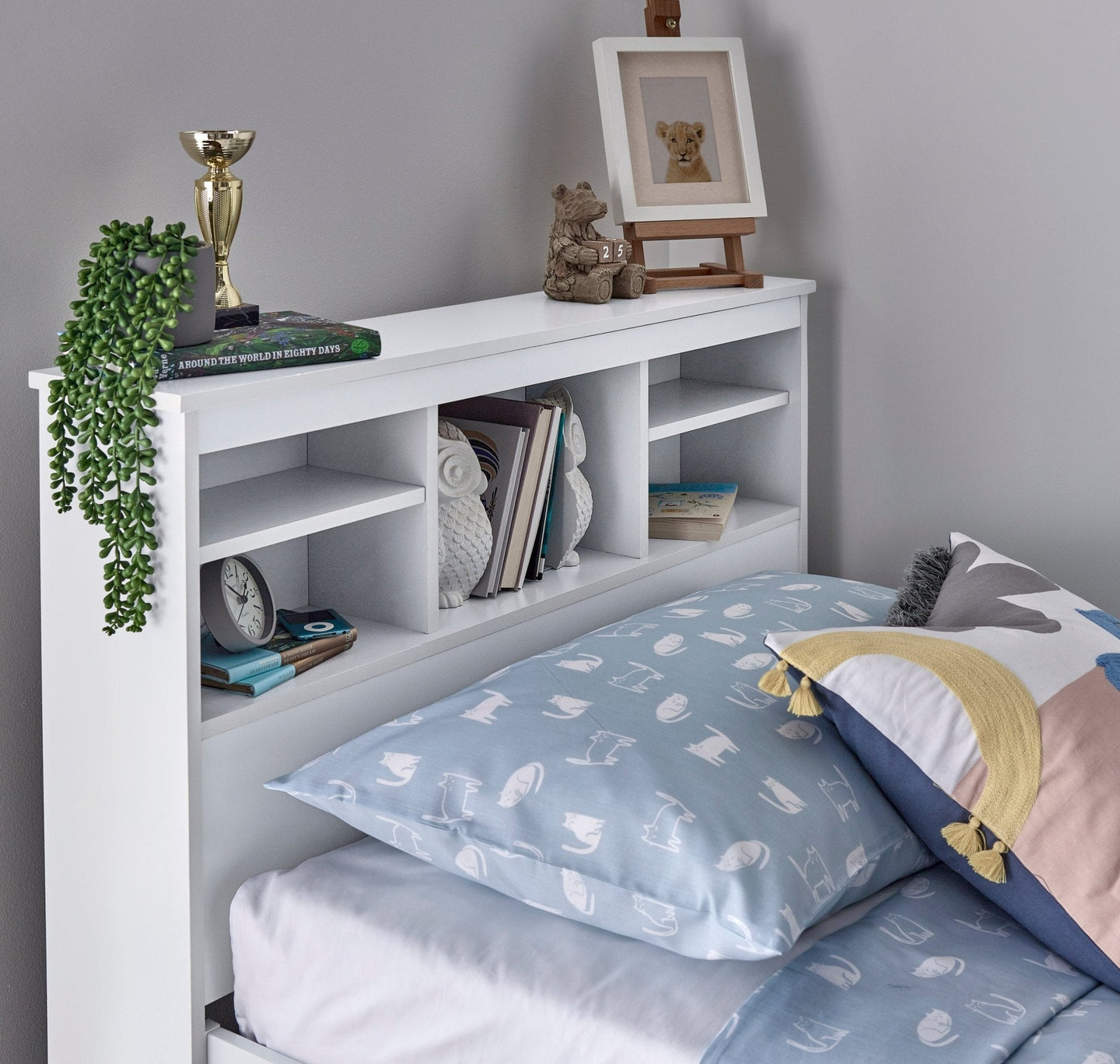 Veera Guest Bed with headboard shelves decorated with books and trinkets.