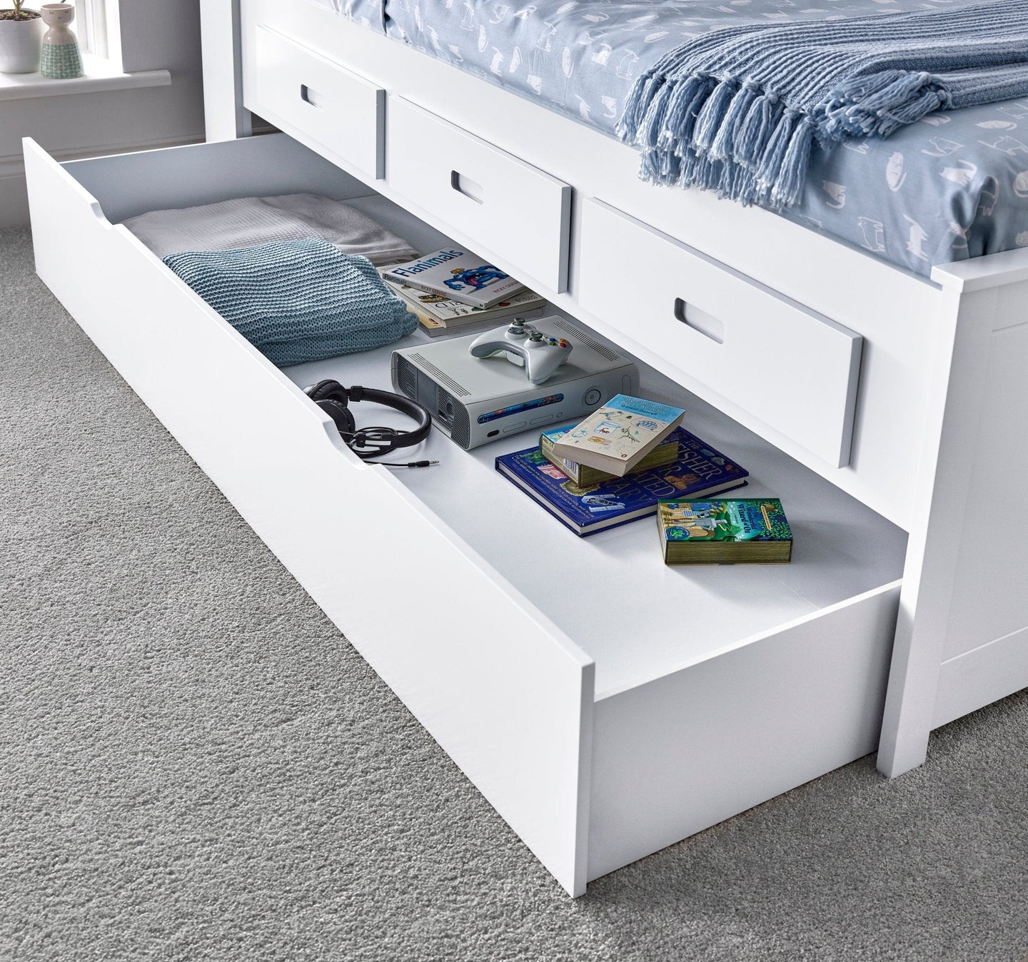 Veera Guest Bed with trundle and storage drawers open, displaying books and accessories.