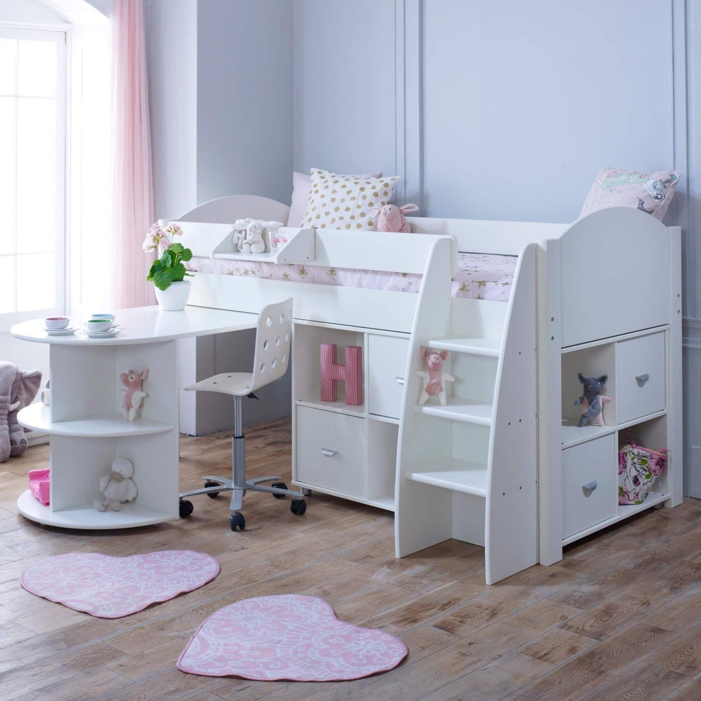 Mid sleeper bed with pull out desk, storage shelves, and reversible ladder in a child's room.