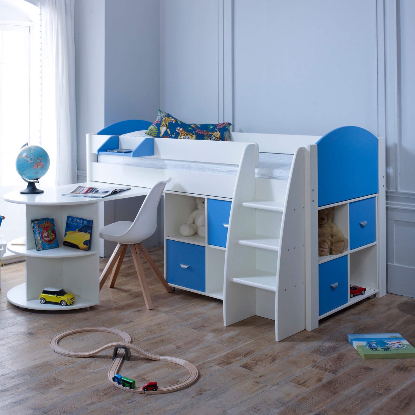 Mid sleeper bed with pull out desk, storage, and blue accents in a kids' room.