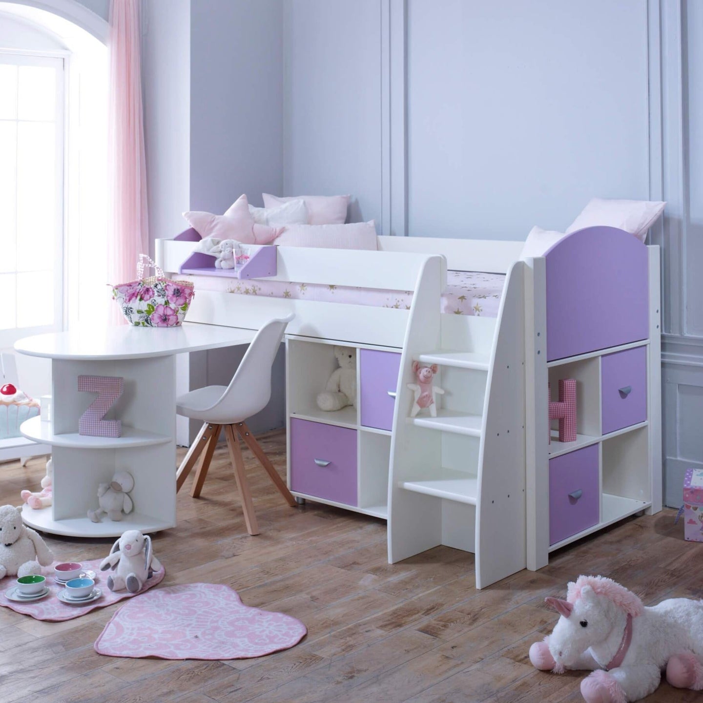 Mid sleeper bed with pull out desk, integrated shelves, storage cubes, and ladder in a child's bedroom.