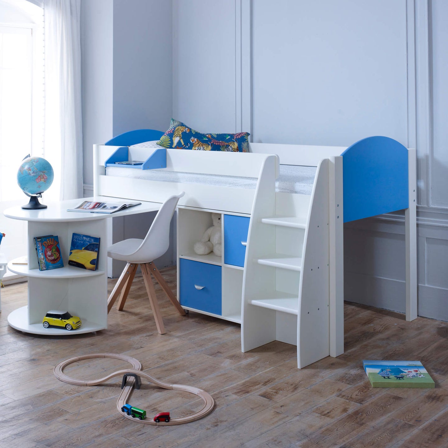 Mid sleeper bed with pull out desk, blue and white design, integrated storage, and ladder for kids' room.