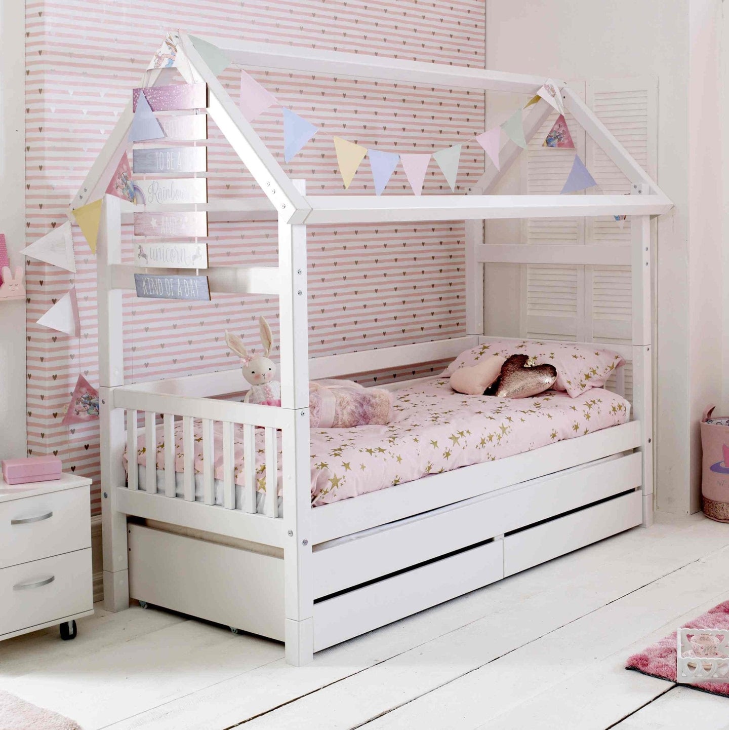 Nordic Playhouse Bed with trundle and storage drawers in a children's room, decorated with bunting.