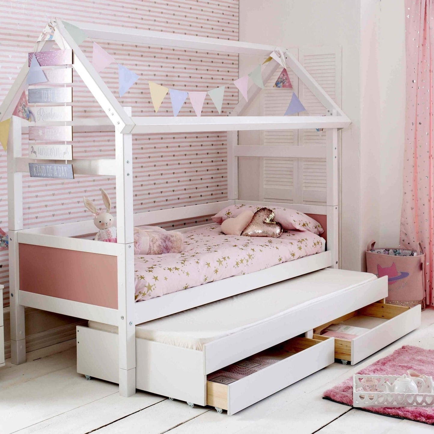 Nordic Playhouse Bed with trundle and storage drawers, kids' low house structure with bunting, optional pull-out guest bed, Scandinavian pine, white lacquer finish.