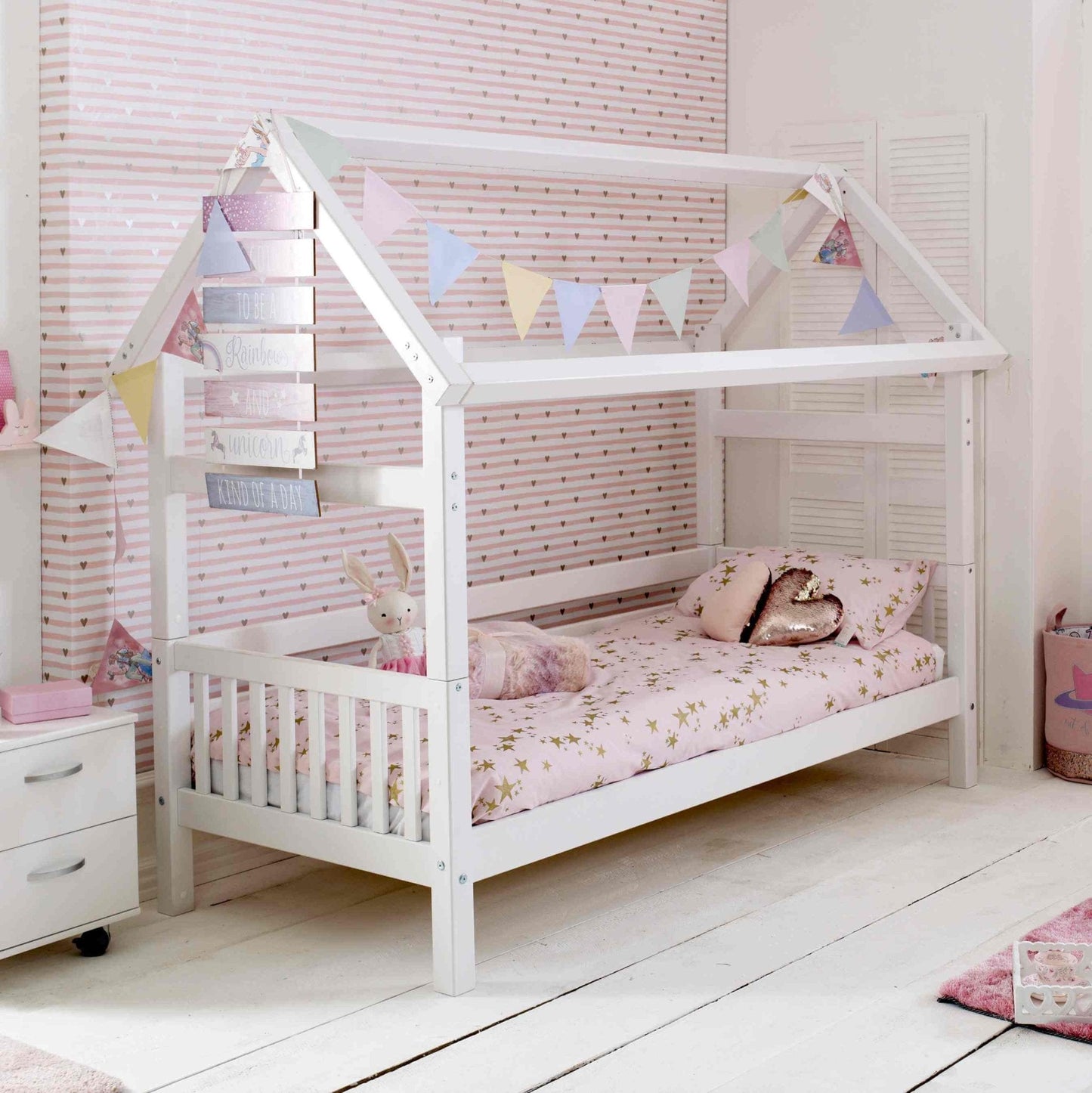 Nordic Playhouse Bed with Optional Trundle and Storage Drawers in a child's room with bunting decoration.