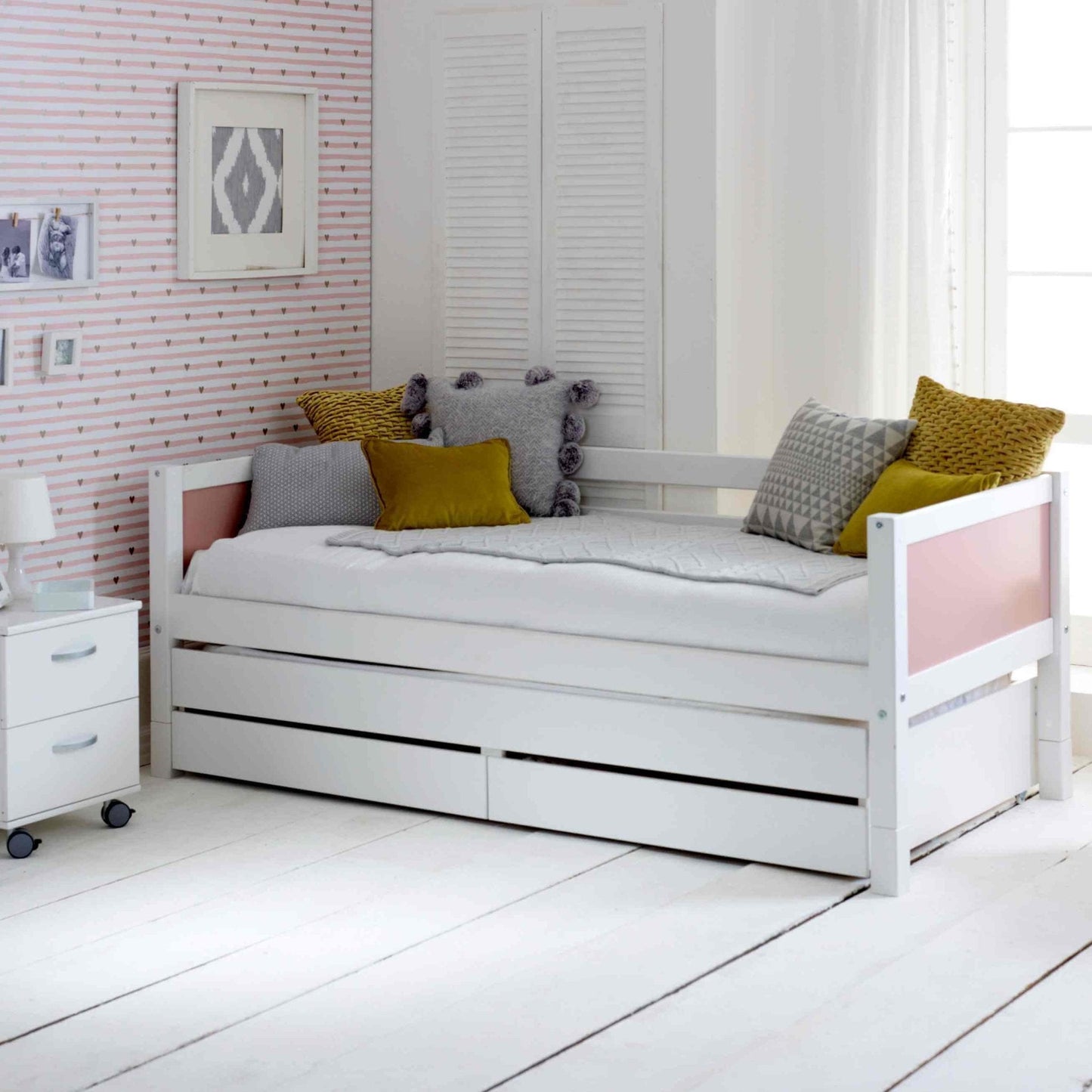 Nordic daybed with trundle pull-out bed and storage drawers in a stylish bedroom setting.