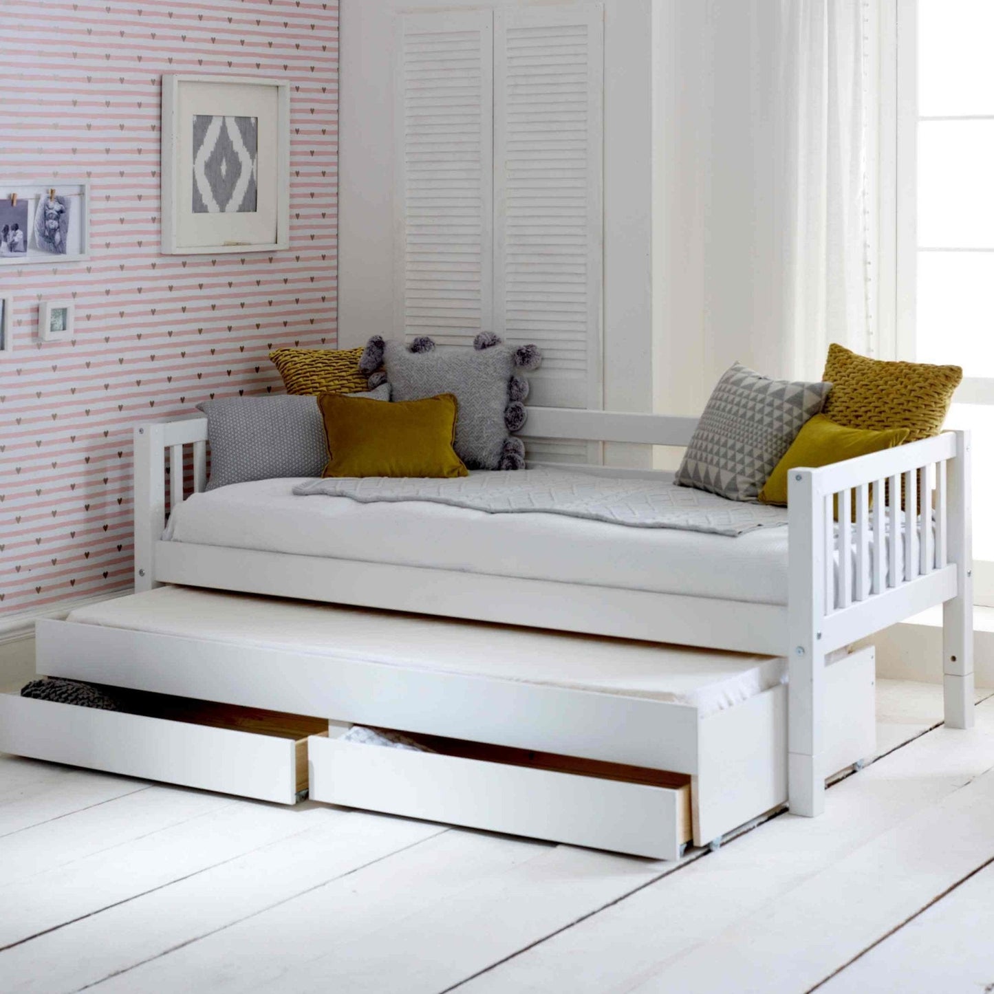 Nordic daybed with trundle pull-out and storage drawers in white room setting.