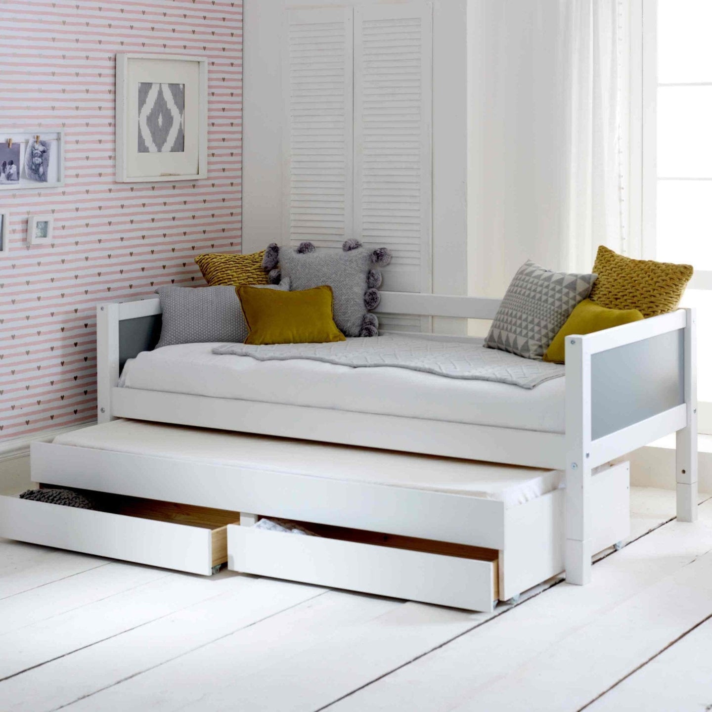 Nordic daybed with trundle pull-out and storage drawers in a bright room setting.