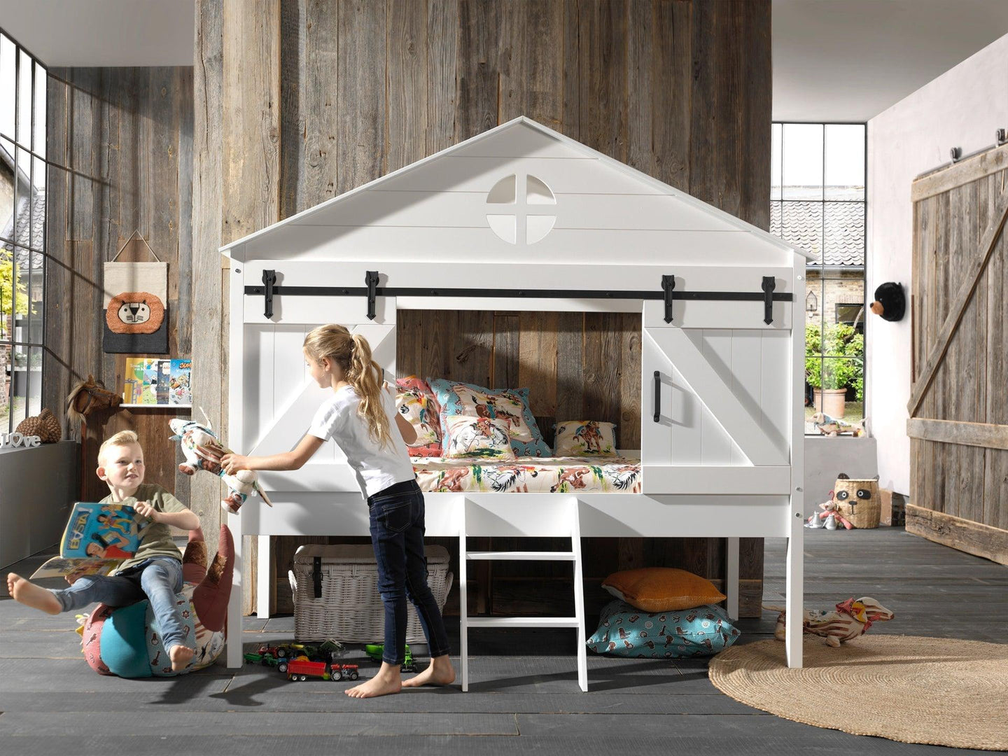 Barn-style Vipack Barnie Midsleeper bed with sliding doors, white lacquered finish, and ladder in a rustic-themed children's bedroom.