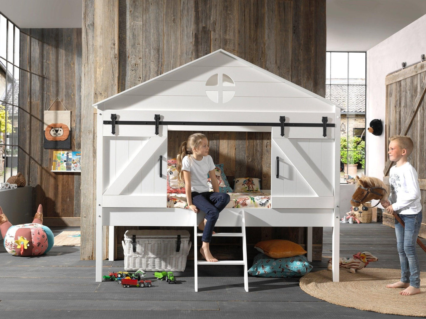 Vipack Barnie Midsleeper bed with barn-inspired design and sliding doors in a rustic children's room.